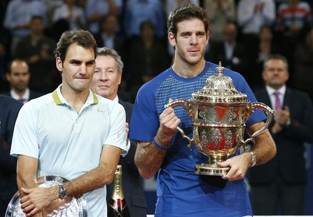 Juan Martin Del Potro (R) of Argentina poses with the winner's trophy after he won his final match against Switzerland's Roger Federer (L) a Juan Martin Del Potro (R) of Argentina poses with the winner's trophy after he won his final match against Switzerland's Roger Federer (L) a