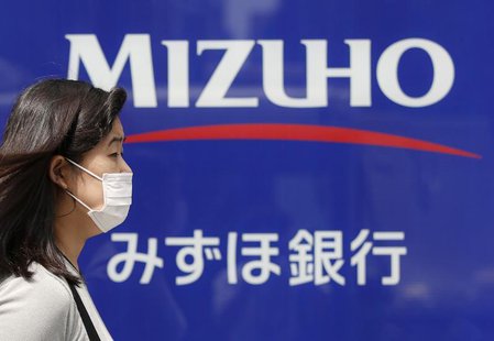 A woman walks past a branch of Mizuho bank, belonging to Mizuho Financial Group, in Tokyo July 31, 2013. REUTERS/Issei Kato A woman walks past a branch of Mizuho bank, belonging to Mizuho Financial Group, in Tokyo July 31, 2013. REUTERS/Issei Kato
