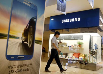 A man using his mobile phone walks past a Samsung Electronics shop in the company's main office building in central Seoul July 23, 2013. REU A man using his mobile phone walks past a Samsung Electronics shop in the company's main office building in central Seoul July 23, 2013. REU