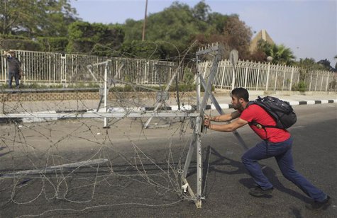 An Al-Azhar University student, a member of the Muslim Brotherhood and supporter of ousted Egyptian President Mohamed Mursi, pushes away an An Al-Azhar University student, a member of the Muslim Brotherhood and supporter of ousted Egyptian President Mohamed Mursi, pushes away an
