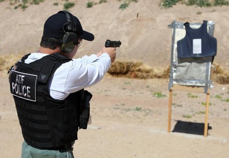 An ATF agent fires rounds from an FN 5.7 Herstal pistol, better known on the streets as a "Cop Killer" weapon, at a body armor vest during a An ATF agent fires rounds from an FN 5.7 Herstal pistol, better known on the streets as a "Cop Killer" weapon, at a body armor vest during a