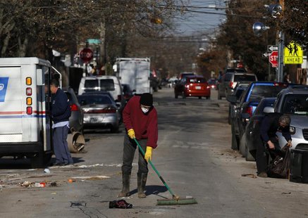 A Midland Beach resident sweeps debris in a street at Staten Island in New York November 14, 2012. REUTERS/Brendan McDermid A Midland Beach resident sweeps debris in a street at Staten Island in New York November 14, 2012. REUTERS/Brendan McDermid