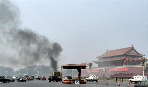 Vehicles travel along Chang'an Avenue as smoke raises in front of a portrait of late Chinese Chairman Mao Zedong at Tiananmen Square in Beij Vehicles travel along Chang'an Avenue as smoke raises in front of a portrait of late Chinese Chairman Mao Zedong at Tiananmen Square in Beij