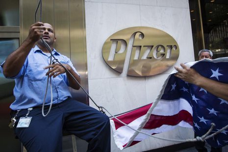 Workers raise a U.S. flag outside the Pfizer building in New York September 4, 2013. REUTERS/Lucas Jackson Workers raise a U.S. flag outside the Pfizer building in New York September 4, 2013. REUTERS/Lucas Jackson