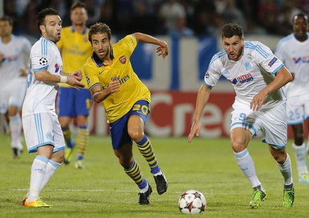 Arsenal's Mathieu Flamini (C) challenges Olympique Marseille's Andre-Pierre Gignac (R) and Mathieu Valbuena during their Group F Champions L Arsenal's Mathieu Flamini (C) challenges Olympique Marseille's Andre-Pierre Gignac (R) and Mathieu Valbuena during their Group F Champions L