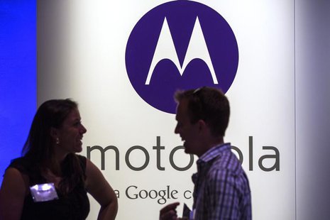 A man and woman laugh in front of a Motorola logo at a launch event for Motorola's new Moto X phone in New York, August 1, 2013. REUTERS/Luc A man and woman laugh in front of a Motorola logo at a launch event for Motorola's new Moto X phone in New York, August 1, 2013. REUTERS/Luc