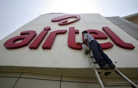 A worker cleans a logo of Bharti Airtel at its zonal office building in the northern Indian city of Chandigarh May 2, 2013. REUTERS/Ajay Ver A worker cleans a logo of Bharti Airtel at its zonal office building in the northern Indian city of Chandigarh May 2, 2013. REUTERS/Ajay Ver