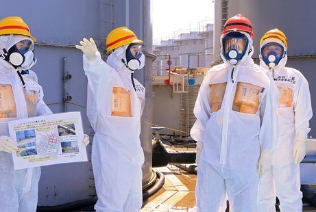 Japan's Prime Minister Shinzo Abe (2nd R), wearing protective suit and mask, is briefed about tanks containing radioactive water by Fukushim Japan's Prime Minister Shinzo Abe (2nd R), wearing protective suit and mask, is briefed about tanks containing radioactive water by Fukushim