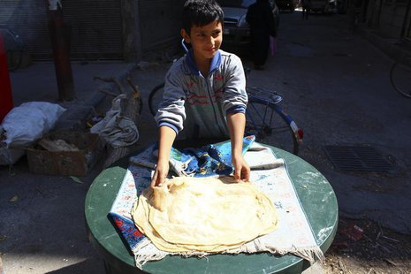 A boy makes bread in Duma neighbourhood, in Damascus September 22, 2013. All official government bakeries were closed since 10 months ago an A boy makes bread in Duma neighbourhood, in Damascus September 22, 2013. All official government bakeries were closed since 10 months ago an