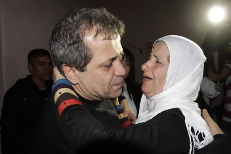 Released Palestinian prisoner Moayyad Hajji, 46, who was arrested in 1992, hugs his sister upon his arrival at his family's house in the Wes Released Palestinian prisoner Moayyad Hajji, 46, who was arrested in 1992, hugs his sister upon his arrival at his family's house in the Wes