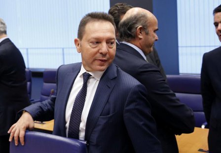 Greece's Finance Minister Yannis Stournaras walks past Spain's Economy Minister Luis de Guindos (back R) during a eurozone finance ministers Greece's Finance Minister Yannis Stournaras walks past Spain's Economy Minister Luis de Guindos (back R) during a eurozone finance ministers