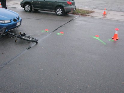 Car vs. bike crash: Green circles indicates position of car and bike rider on pavement after crash. Car vs. bike crash: Green circles indicates position of car and bike rider on pavement after crash.