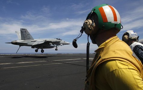 A U.S. Navy F/A 18 Hornet aircraft prepares its tailhook to catch an arresting wire in a landing maneuver during a tour of the USS Nimitz ai A U.S. Navy F/A 18 Hornet aircraft prepares its tailhook to catch an arresting wire in a landing maneuver during a tour of the USS Nimitz ai