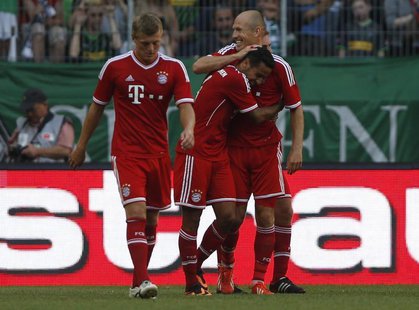 Bayern Munich's Thiago of Spain (C) celebrates his goal against Borussia Moenchengladbach with Arjen Robben (R) and Toni Kroos during their Bayern Munich's Thiago of Spain (C) celebrates his goal against Borussia Moenchengladbach with Arjen Robben (R) and Toni Kroos during their