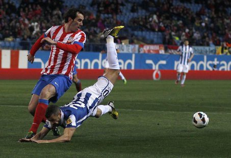 Atletico Madrid's Diego Godin (L) and Espanyol's Simao Sabrosa fight for the ball during their Spanish first division soccer match at Vicent Atletico Madrid's Diego Godin (L) and Espanyol's Simao Sabrosa fight for the ball during their Spanish first division soccer match at Vicent