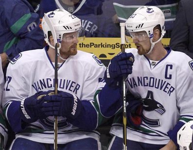 Vancouver Canucks left wing Daniel Sedin (L) talks with his twin brother Henrik while on the bench during Game 4 of their NHL Western Confer Vancouver Canucks left wing Daniel Sedin (L) talks with his twin brother Henrik while on the bench during Game 4 of their NHL Western Confer