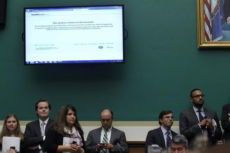 Staff members working for Republican U.S. congressmen look on under an image of the Healthcare.gov website, which is currently down, as U.S. Staff members working for Republican U.S. congressmen look on under an image of the Healthcare.gov website, which is currently down, as U.S.