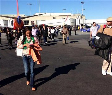 Airline passengers are evacuated to the tarmac in this picture courtesy of Natalie Morin at Los Angeles International Airport November 1, 2013. Credit: Reuters/Natalie Morin/Handout via Reuters Airline passengers are evacuated to the tarmac in this picture courtesy of Natalie Morin at Los Angeles International Airport November 1, 2013. Credit: Reuters/Natalie Morin/Handout via Reuters
