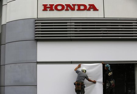 Workers stand under the logo of Honda Motor Co. outside the company's headquarters in Tokyo October 30, 2013. REUTERS/Issei Kato Workers stand under the logo of Honda Motor Co. outside the company's headquarters in Tokyo October 30, 2013. REUTERS/Issei Kato