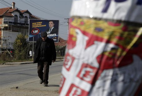 A Kosovar Serb walks past election campaign posters of Samostalna Liberalna Stranka (Independent Liberal Party) and Gradanska inicijativa Sr A Kosovar Serb walks past election campaign posters of Samostalna Liberalna Stranka (Independent Liberal Party) and Gradanska inicijativa Sr