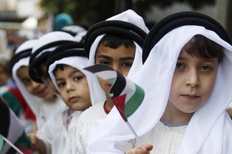 Palestinian children wearing traditional clothes, wave their national flags as they take part in a march to mark the 65th anniversary of Nak Palestinian children wearing traditional clothes, wave their national flags as they take part in a march to mark the 65th anniversary of Nak
