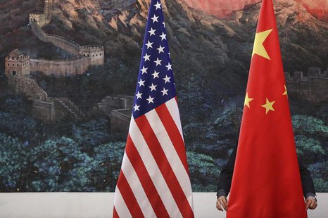 A Chinese man adjusts a China flag before a news conference attended by Chinese Foreign Minister Yang Jiechi and U.S. Secretary of State Hil A Chinese man adjusts a China flag before a news conference attended by Chinese Foreign Minister Yang Jiechi and U.S. Secretary of State Hil
