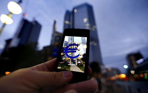 A passerby uses his smartphone to take a picture of the euro sign landmark in front of the headquarters of the European Central Bank (ECB) i A passerby uses his smartphone to take a picture of the euro sign landmark in front of the headquarters of the European Central Bank (ECB) i