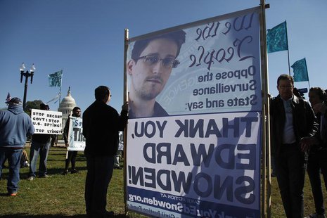 Demonstrators hold signs supporting fugitive former NSA contractor Edward Snowden as they gather for the "Stop Watching Us: A Rally Against Demonstrators hold signs supporting fugitive former NSA contractor Edward Snowden as they gather for the "Stop Watching Us: A Rally Against