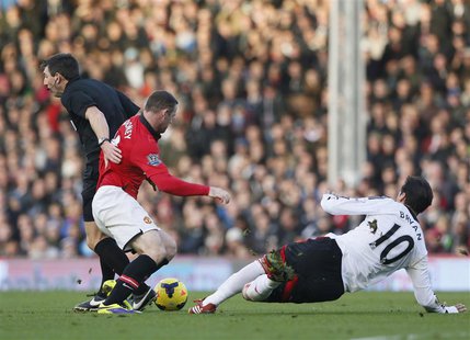 Manchester United's Wayne Rooney (C) collides with referee Lee Probert (L) as he is challenged by Fulham's Bryan Ruiz during their English P Manchester United's Wayne Rooney (C) collides with referee Lee Probert (L) as he is challenged by Fulham's Bryan Ruiz during their English P