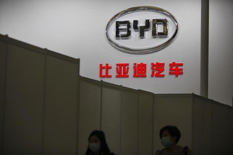 Women walk in front of the logo of Chinese car manufacturer BYD (Build Your Dreams) Auto stage before the opening of the 15th Shanghai Inter Women walk in front of the logo of Chinese car manufacturer BYD (Build Your Dreams) Auto stage before the opening of the 15th Shanghai Inter