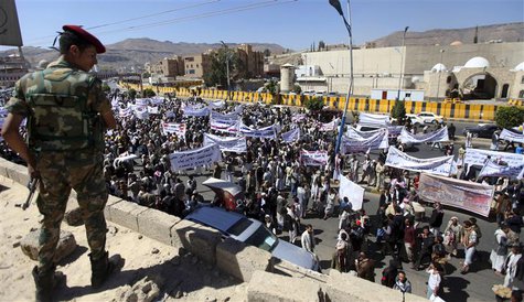 A soldier guarding the home of Yemeni President Abd-Rabbu Mansour Hadi stands on the roof of neighbouring houses during a protest outside Ha A soldier guarding the home of Yemeni President Abd-Rabbu Mansour Hadi stands on the roof of neighbouring houses during a protest outside Ha