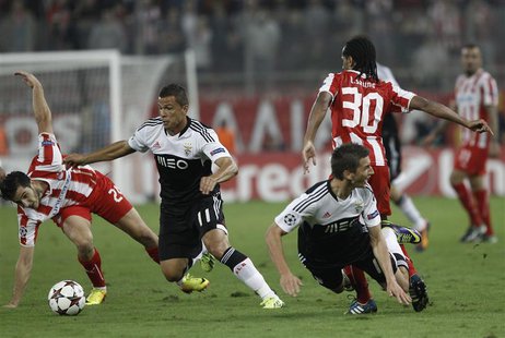 Olympiakos' Kostas Manolas (L) fights for the ball against Benfica's Lima (2nd L) during their Champions League soccer match at Karaiskaki s Olympiakos' Kostas Manolas (L) fights for the ball against Benfica's Lima (2nd L) during their Champions League soccer match at Karaiskaki s