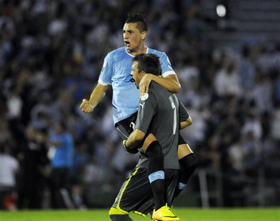 Uruguay's goalkeeper Fernando Muslera celebrates with teammate Jose Gimenez after their team scored against Colombia during their 2014 World Uruguay's goalkeeper Fernando Muslera celebrates with teammate Jose Gimenez after their team scored against Colombia during their 2014 World