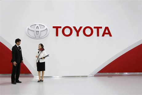 Staff stand under Toyota Motor's logo at the company's showroom in Tokyo November 6, 2013. Toyota Motor Corp will raise its operating profit Staff stand under Toyota Motor's logo at the company's showroom in Tokyo November 6, 2013. Toyota Motor Corp will raise its operating profit