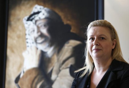 Suha Arafat poses near a portrait of her late husband and Palestinian leader Yasser Arafat before watching the wreath laying ceremony after Suha Arafat poses near a portrait of her late husband and Palestinian leader Yasser Arafat before watching the wreath laying ceremony after