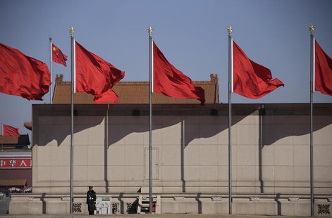 A paramilitary policeman stands guard under flags outside the Great Hall of the People during the third plenary session of the National Peop A paramilitary policeman stands guard under flags outside the Great Hall of the People during the third plenary session of the National Peop