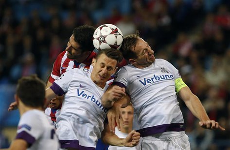Atletico Madrid's Raul Garcia (L) fights to head the ball with Austria Vienna's Florian Mader (C) and Manuel Ortlechner during their Champio Atletico Madrid's Raul Garcia (L) fights to head the ball with Austria Vienna's Florian Mader (C) and Manuel Ortlechner during their Champio