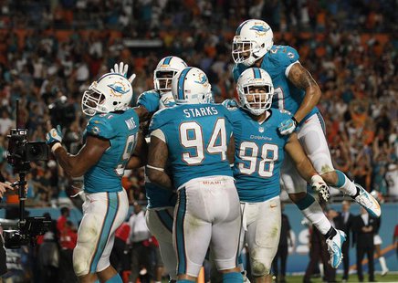 Miami Gardens, FL, USA; Miami Dolphins defensive end Cameron Wake (91) celebrates with defensive tackle Randy Starks (94) defensive tackle J Miami Gardens, FL, USA; Miami Dolphins defensive end Cameron Wake (91) celebrates with defensive tackle Randy Starks (94) defensive tackle J