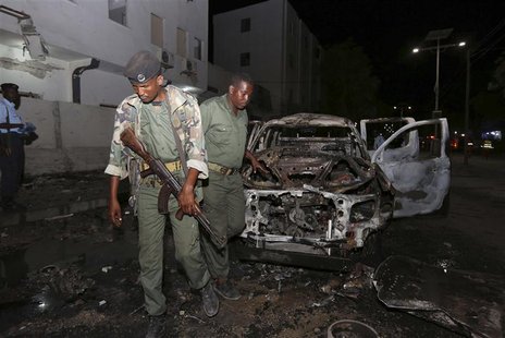 Somali policemen inspect the scene of an explosion outside the Maka Al-Mukarama hotel in Somalia's capital Mogadishu, November 8, 2013. REUT Somali policemen inspect the scene of an explosion outside the Maka Al-Mukarama hotel in Somalia's capital Mogadishu, November 8, 2013. REUT