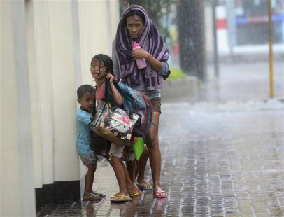 A mother takes refuge with her children as Typhoon Haiyan hits Cebu city, central Philippines November 8, 2013. Typhoon Haiyan, the stronges A mother takes refuge with her children as Typhoon Haiyan hits Cebu city, central Philippines November 8, 2013. Typhoon Haiyan, the stronges