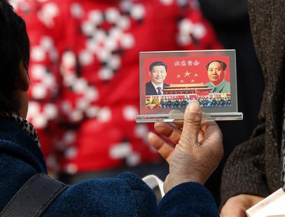 A street vendor displays a souvenir with pictures of Chinese President Xi Jinping (L) and the late Chinese Chairman Mao Zedong to visitors a A street vendor displays a souvenir with pictures of Chinese President Xi Jinping (L) and the late Chinese Chairman Mao Zedong to visitors a