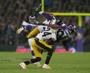 Minnesota Vikings wide receiver Jerome Simpson (R) is brought down by Pittsburgh Steelers cornerback Ike Taylor and another defender in the Minnesota Vikings wide receiver Jerome Simpson (R) is brought down by Pittsburgh Steelers cornerback Ike Taylor and another defender in the