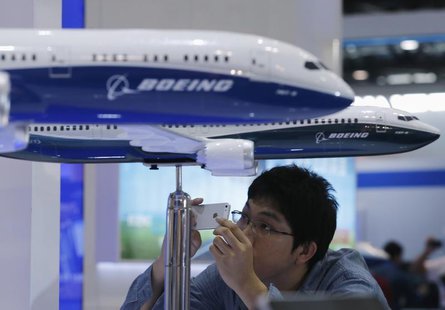 A visitor takes a picture of miniature Boeing passenger aircraft on display at Aviation Expo China 2013 in Beijing September 25, 2013. REUTE A visitor takes a picture of miniature Boeing passenger aircraft on display at Aviation Expo China 2013 in Beijing September 25, 2013. REUTE