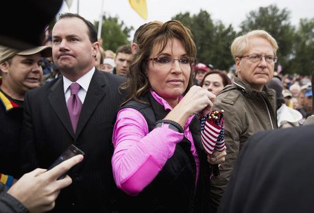 Senator Mike Lee (L)(R-UT) watches as Former Alaska Governor Sarah Palin hands out American Flags to protesters during the "Million Vet Marc Senator Mike Lee (L)(R-UT) watches as Former Alaska Governor Sarah Palin hands out American Flags to protesters during the "Million Vet Marc
