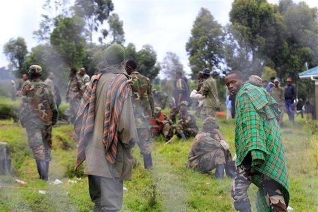 Congolese M23 rebels walk inside an enclosure after surrendering to Uganda's government at Rugwerero village in Kisoro district, 489km (293 Congolese M23 rebels walk inside an enclosure after surrendering to Uganda's government at Rugwerero village in Kisoro district, 489km (293