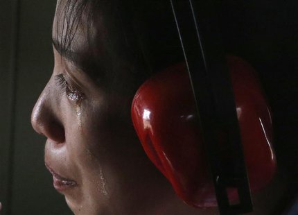 A typhoon survivor cries while she and her sick baby (not pictured) are evacuated by a military helicopter from Guiwan, Samar, that was amon A typhoon survivor cries while she and her sick baby (not pictured) are evacuated by a military helicopter from Guiwan, Samar, that was amon