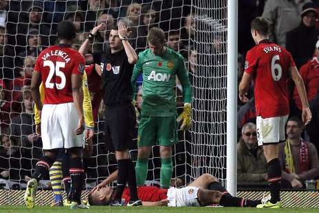 Referee Michael Oliver signals on the medics as Manchester United's Nemanja Vidic lays injured during their English Premier League soccer ma Referee Michael Oliver signals on the medics as Manchester United's Nemanja Vidic lays injured during their English Premier League soccer ma