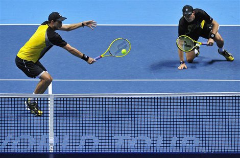 Bob Bryan of the U.S. slips as his brother Mike Bryan plays a shot during their men's doubles final tennis match against David Marrero of Sp Bob Bryan of the U.S. slips as his brother Mike Bryan plays a shot during their men's doubles final tennis match against David Marrero of Sp