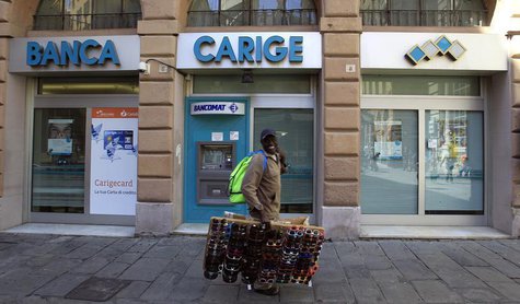 A street vendor walks in front of Carige bank in Genoa May 14, 2013. REUTERS/Alessandro Garofalo A street vendor walks in front of Carige bank in Genoa May 14, 2013. REUTERS/Alessandro Garofalo