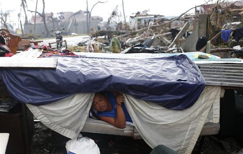 A typhoon victim looks out from a makeshift shelter along a road in Palo, Leyte province in central Philippines, which was battered by Typho A typhoon victim looks out from a makeshift shelter along a road in Palo, Leyte province in central Philippines, which was battered by Typho